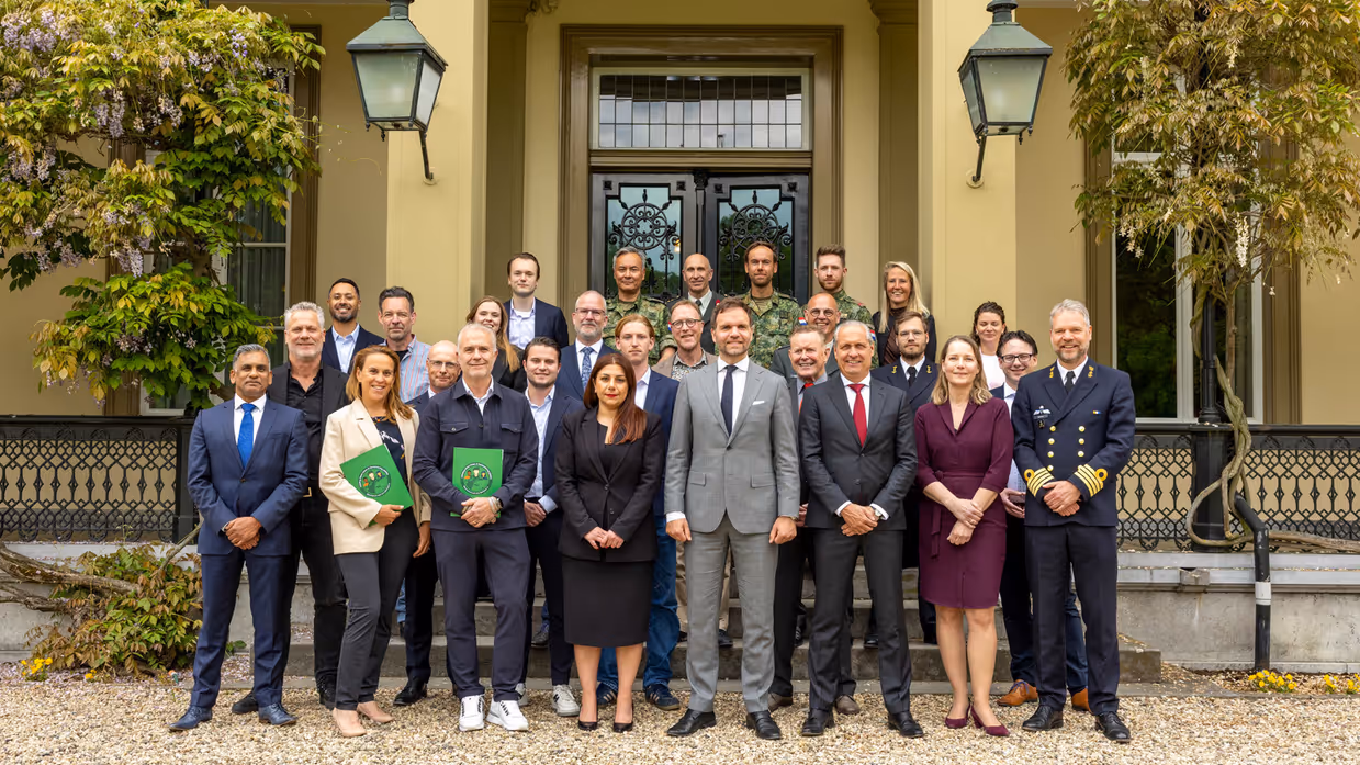Groepsfoto van de staatssecretaris met werkgevers en reservisten.