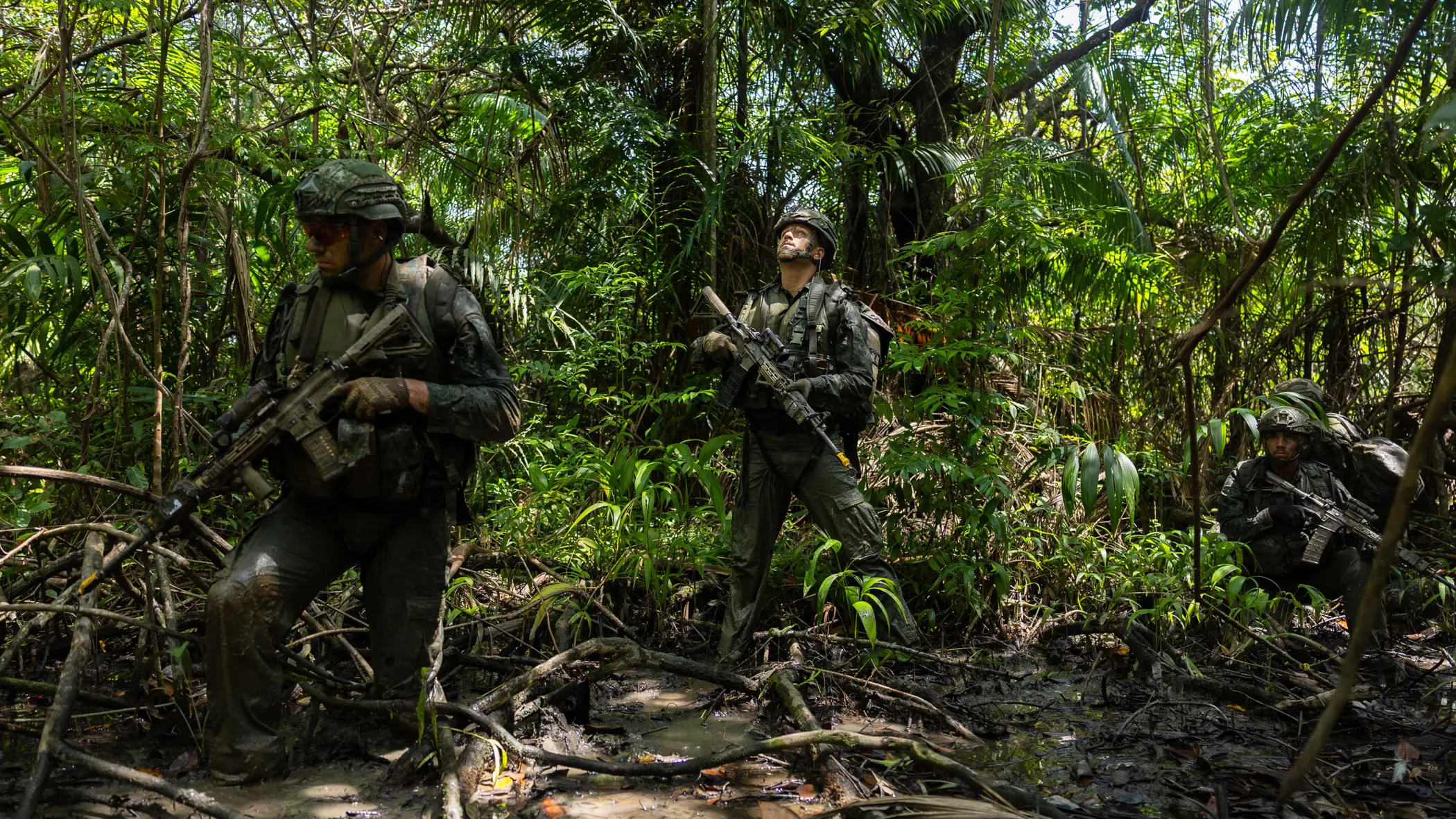 2 militairen lopen op patrouille door de jungle.