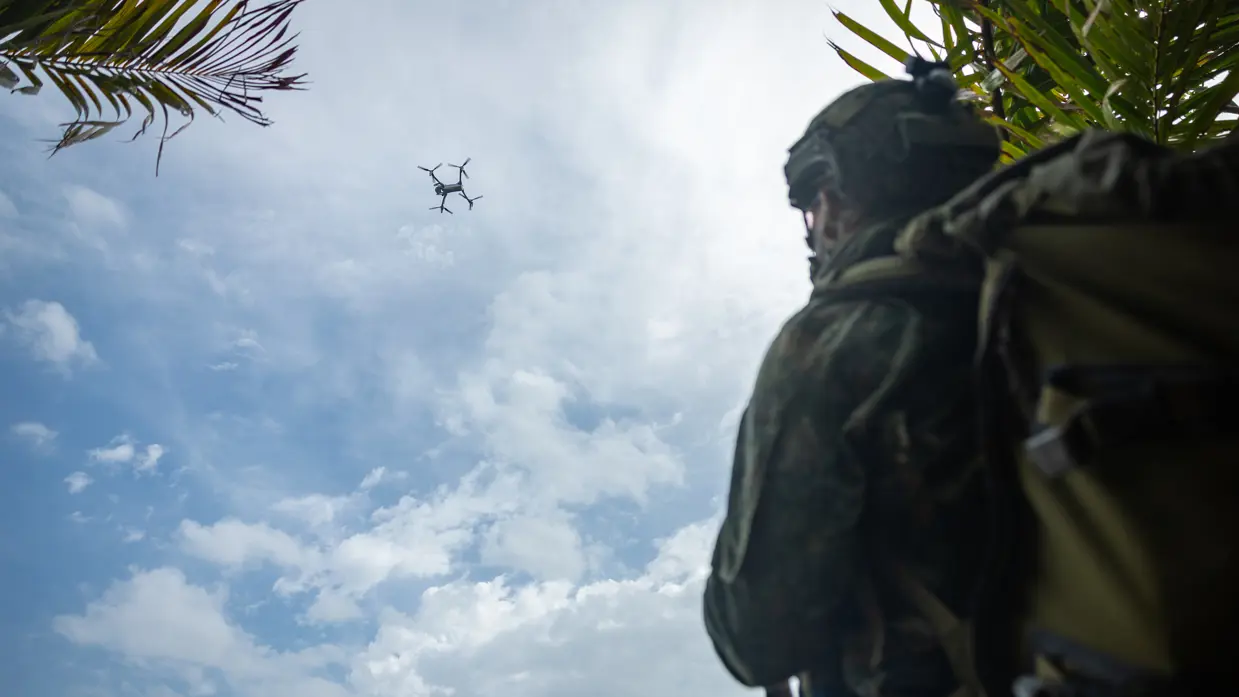 Op de 4 foto’s varen mariniers door de jungle, laat een marinier een drone op, bewaken mariniers een gevangene op het strand en stappen mariniers in een boot.