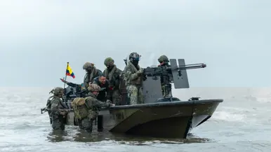 Op de 4 foto’s varen mariniers door de jungle, laat een marinier een drone op, bewaken mariniers een gevangene op het strand en stappen mariniers in een boot.