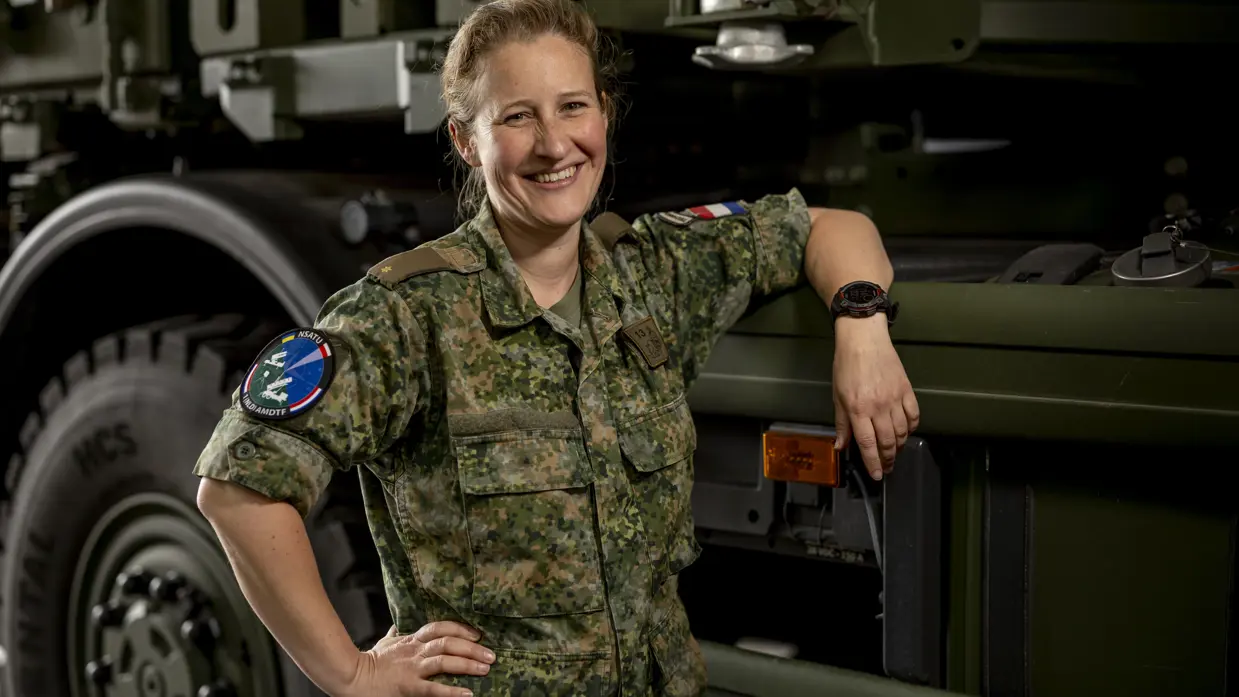 Op de linkerfoto zit Suzanne in haar werkcontainer achter de computer. Op de rechterfoto leunt Suzanne met een arm op een vrachtwagen.