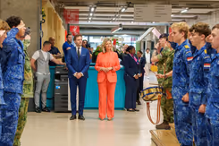 Leerlingen salueren voor de voorzitter van het bestuur en de staatssecretaris.