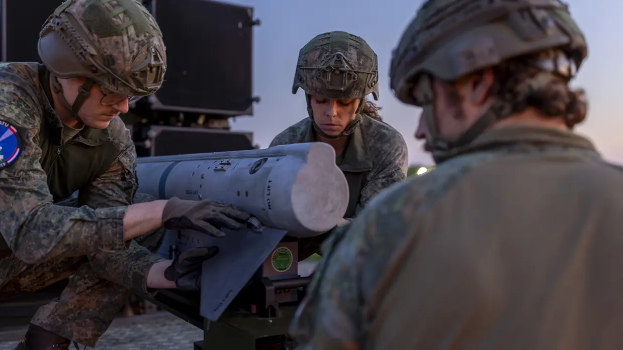 Op de linkerfoto een NASAMS-lanceerinrichting in het avondrood. Op de rechterfoto monteren militairen stabilisatievinnen op een luchtdoelraket.