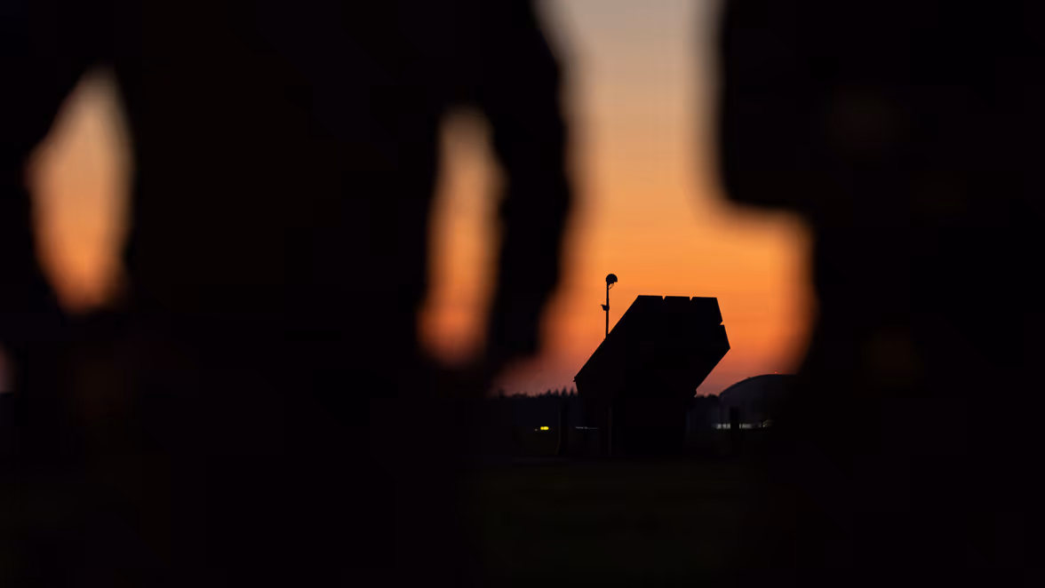 Silhouet van een NASAMS-lanceerinstallatie in het avondrood. 