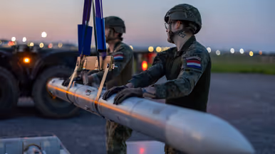 Militairen plaatsen een luchtdoelraket in een launcher.