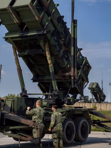 Op de linkerfoto staan Patriot-lanceerinstallaties op een rij. Op de rechterfoto voeren twee militairen handelingen uit aan een Patriot-systeem.