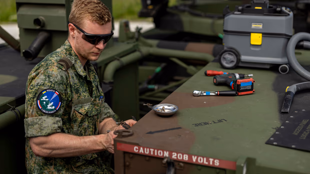 Op de linkerfoto sleutelt een militair aan een wapensysteem. Op de rechterfoto een mouwembleem van de AMDTF.