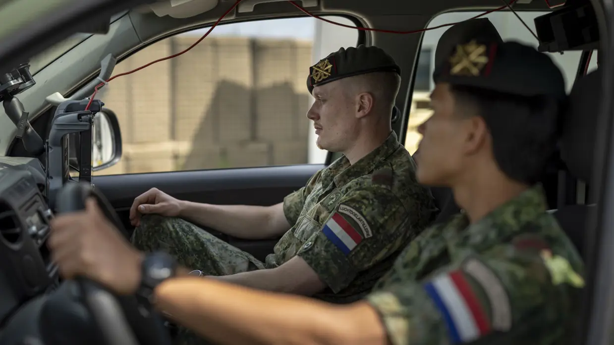 Op de linkerfoto lopen twee militairen naar een Amarok-legervoertuig met daarop een grijze bol. Op de rechterfoto zitten twee militairen in een Amarok-legervoertuig en kijken naar een scherm. 