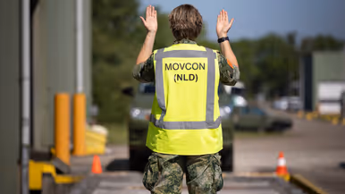 Op de linkerfoto een militair met geel hesje met daarop de letters MOVCON. Hij gebaart naar een voertuig. Op de rechterfoto een kleine file aan legervoertuigen bestemd voor Oekraïne. 