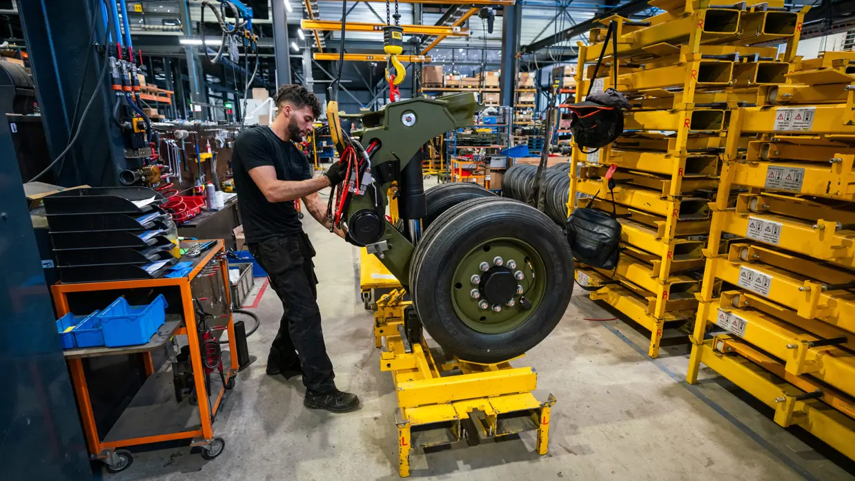 Monteur in garage sleutelt aan wiel oplegger.