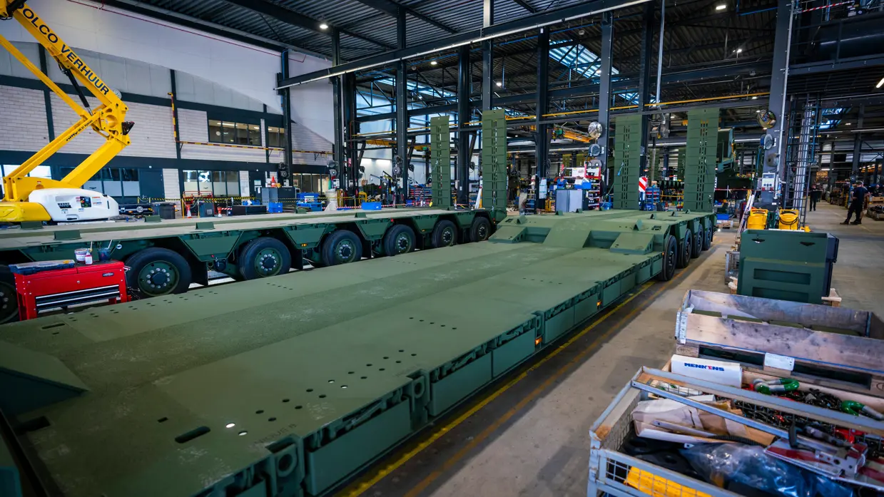 Oplegger in legergroen in servicehal fabriek.