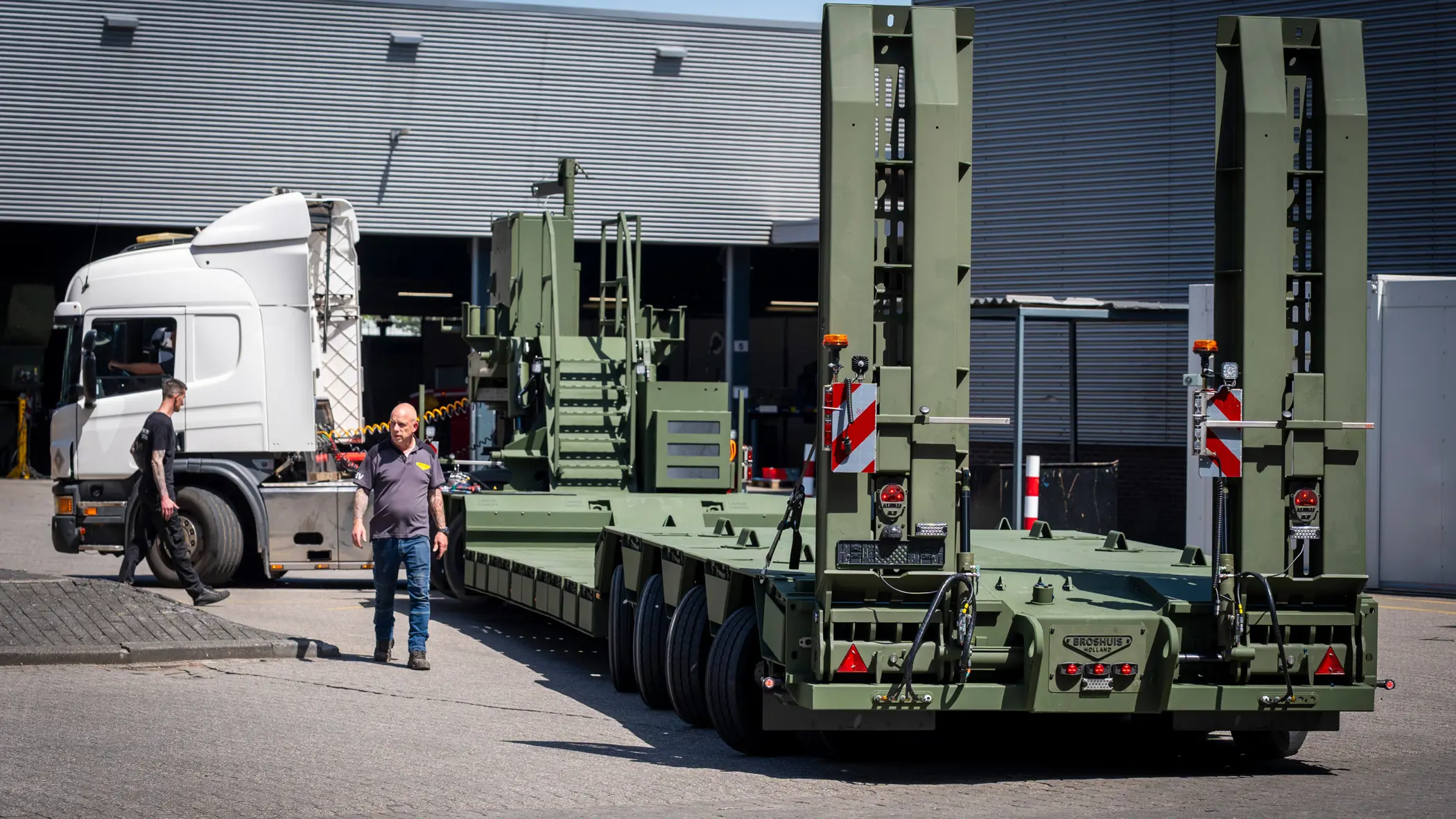 Vrachtwagen met oplegger manoeuvreert op bedrijventerrein.