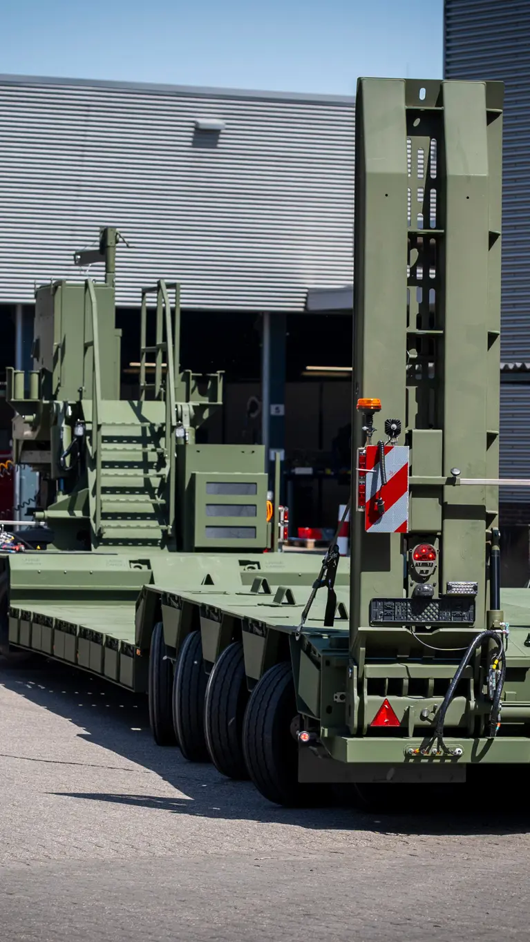 Vrachtwagen met oplegger manoeuvreert op bedrijventerrein.