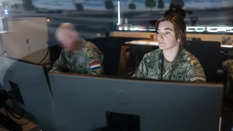 Een militair kijkt door de ramen van control room naar wat er zich binnenin de Stingerdome afspeelt.