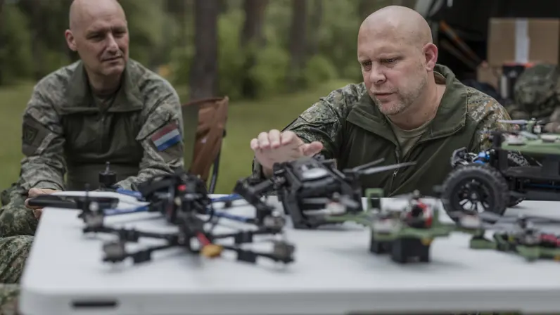 Kapitein Max en luitenant-kolonel Roeland bespreken verschillende drones en onbemande systemen tijdens oefening Fighter Lion.
