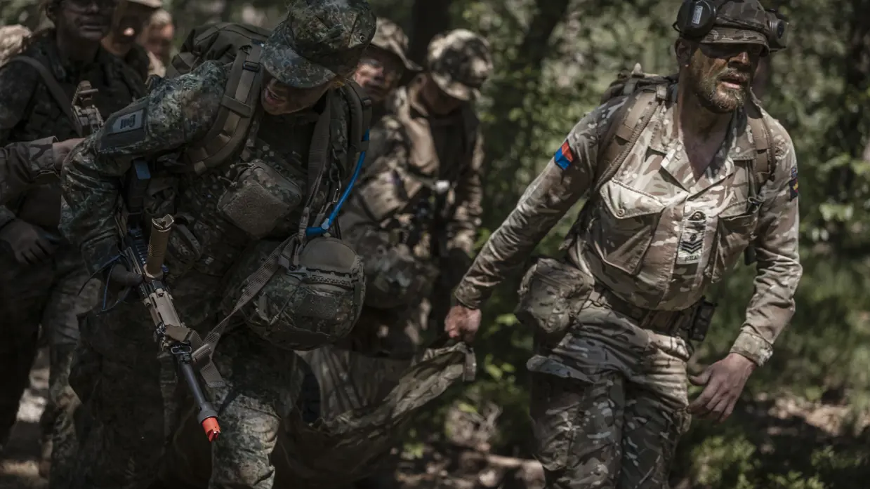 Studentmilitairen en instructeur bewegen zich door het bos.