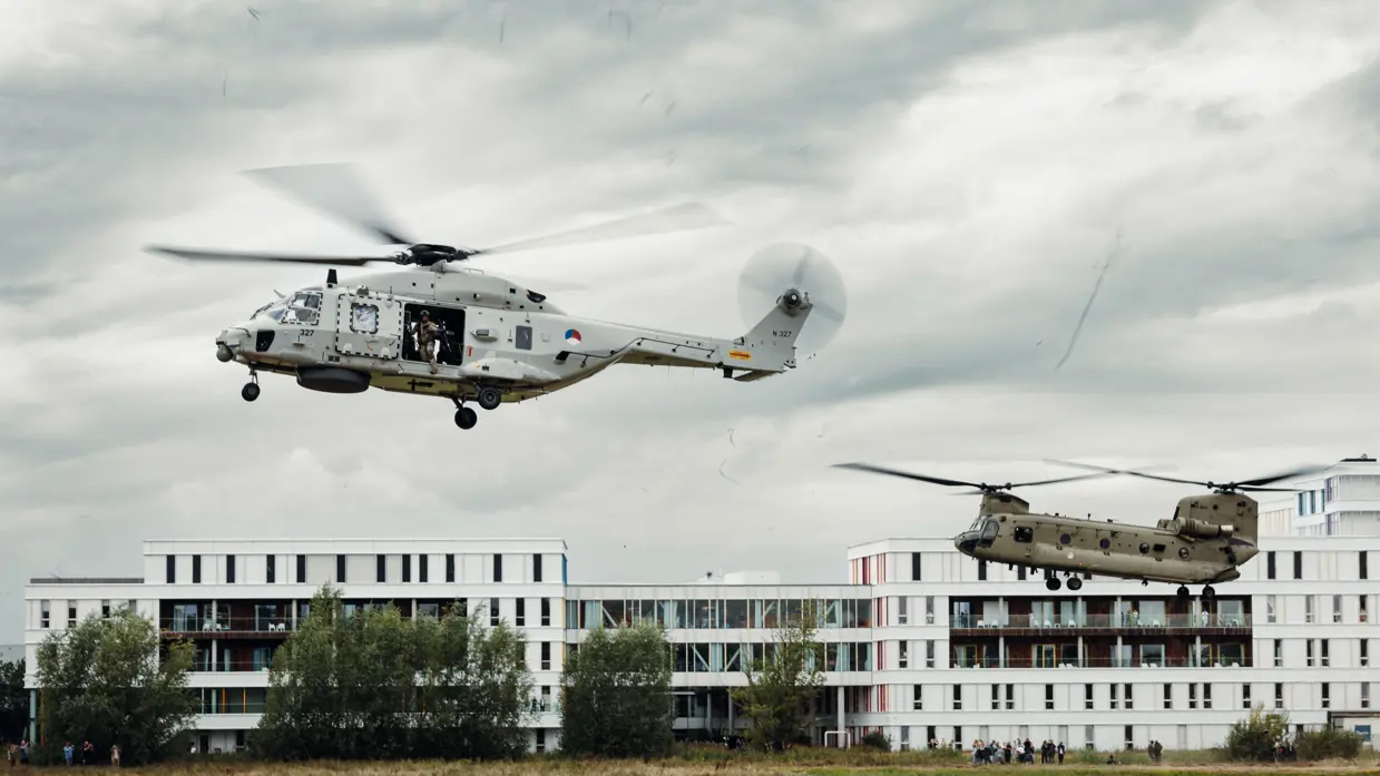 Een tweetal helikopters vliegt door de lucht.