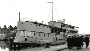 Een oud schip met een groep vrouwen in uniform in de haven