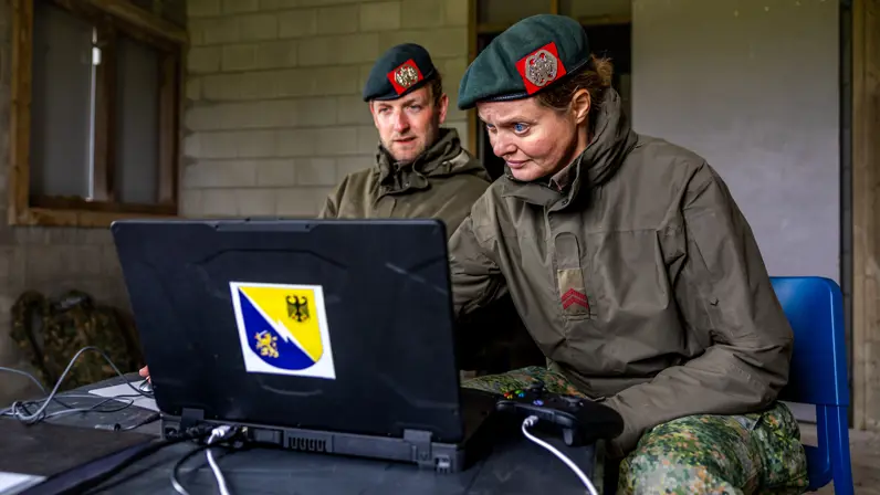  Lucas en Syl achter een laptop.