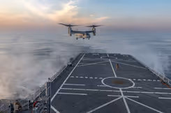 Een vliegtuig hangt boven een scheepsdek.