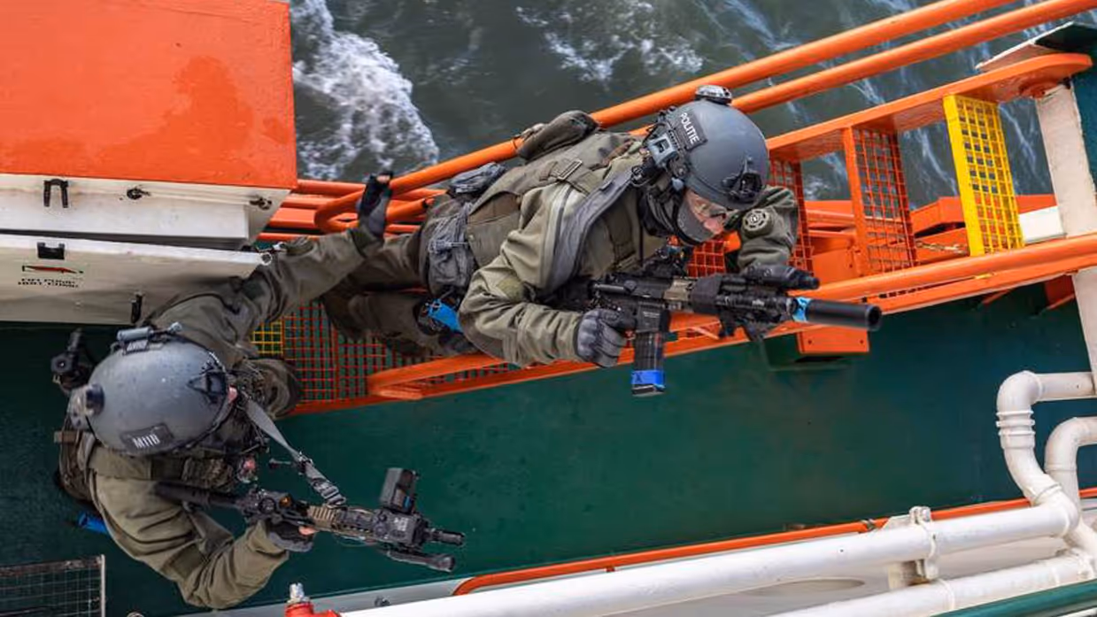 2 gehelmde mannen beklimmen stalen trap.