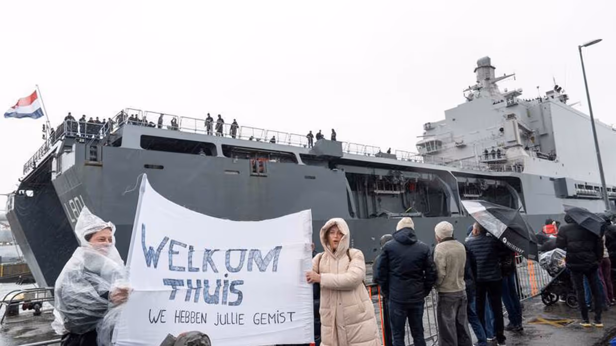Verwanten met spandoek bij terugkeer Zr.Ms. Johan de Witt in Den Helder