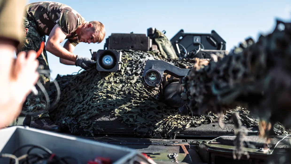 Een militair bovenop een pantservoertuig.