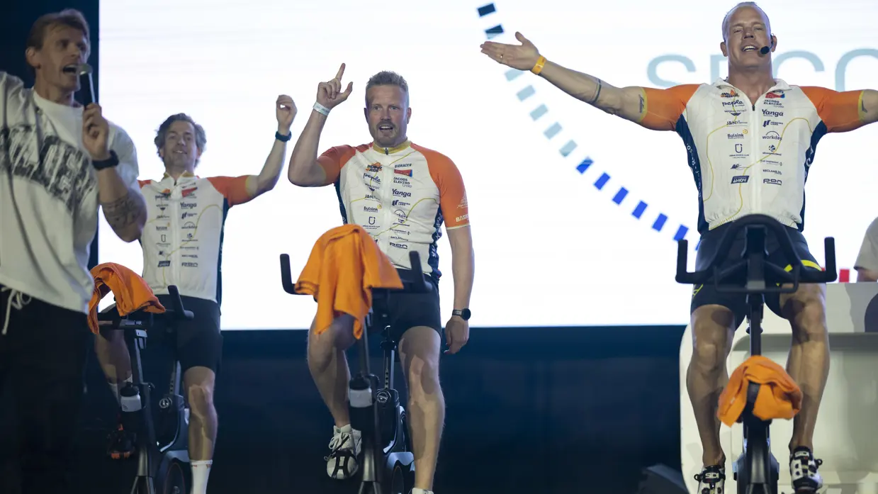 Deelnemers van team Marechaussee aan de Alpe d’HuZes Indoorride 2026 op een podium.