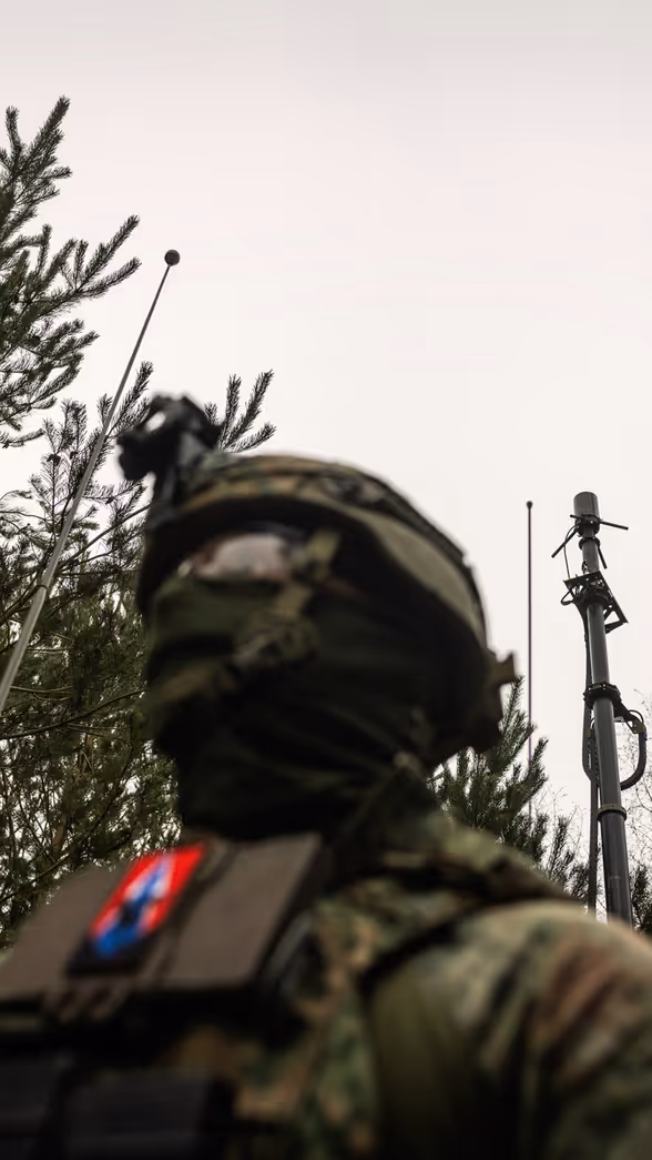 Een militair in het bos die een stabiel netwerk opzet.