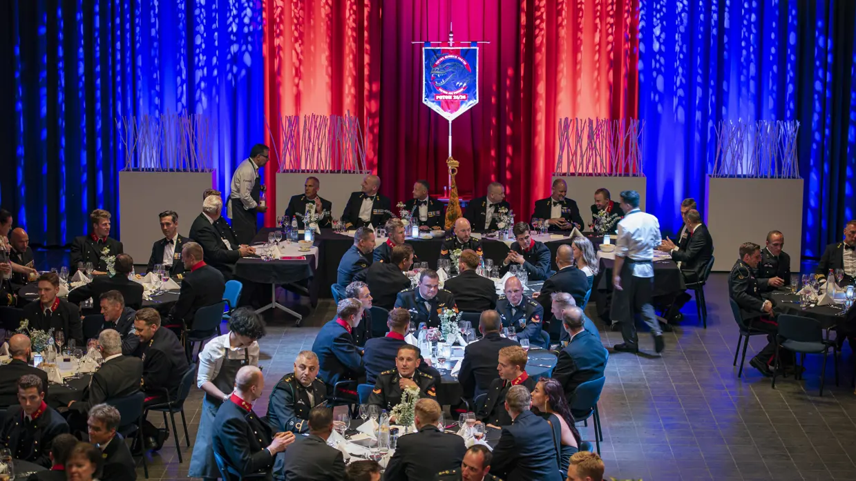 Een zaal met meerdere tafel waaraan mariniers met elkaar in gesprek zijn.