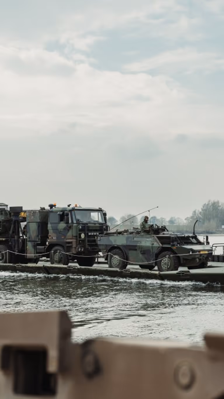 Militair materieel op een mobiel brugsysteem.