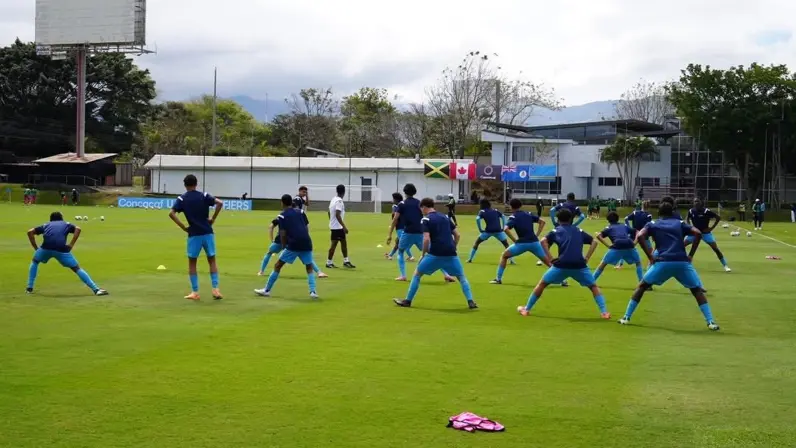 Voetballers doen oefeningen op een trainingsveld. 