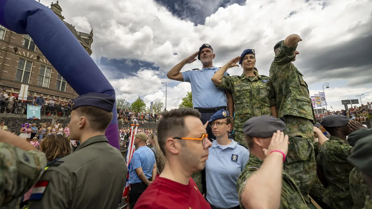 Militairen salueren naar de menigte bij de grachten.