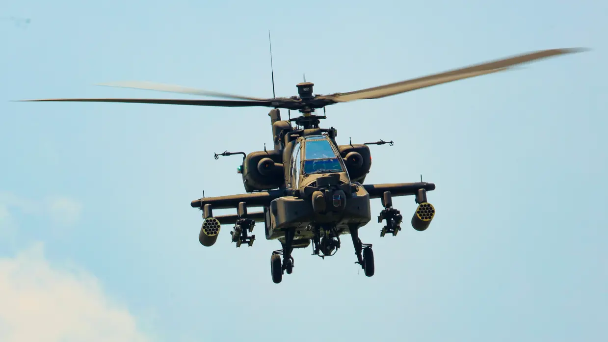 Een militaire helikopter van voren gezien onder een blauwe lucht.