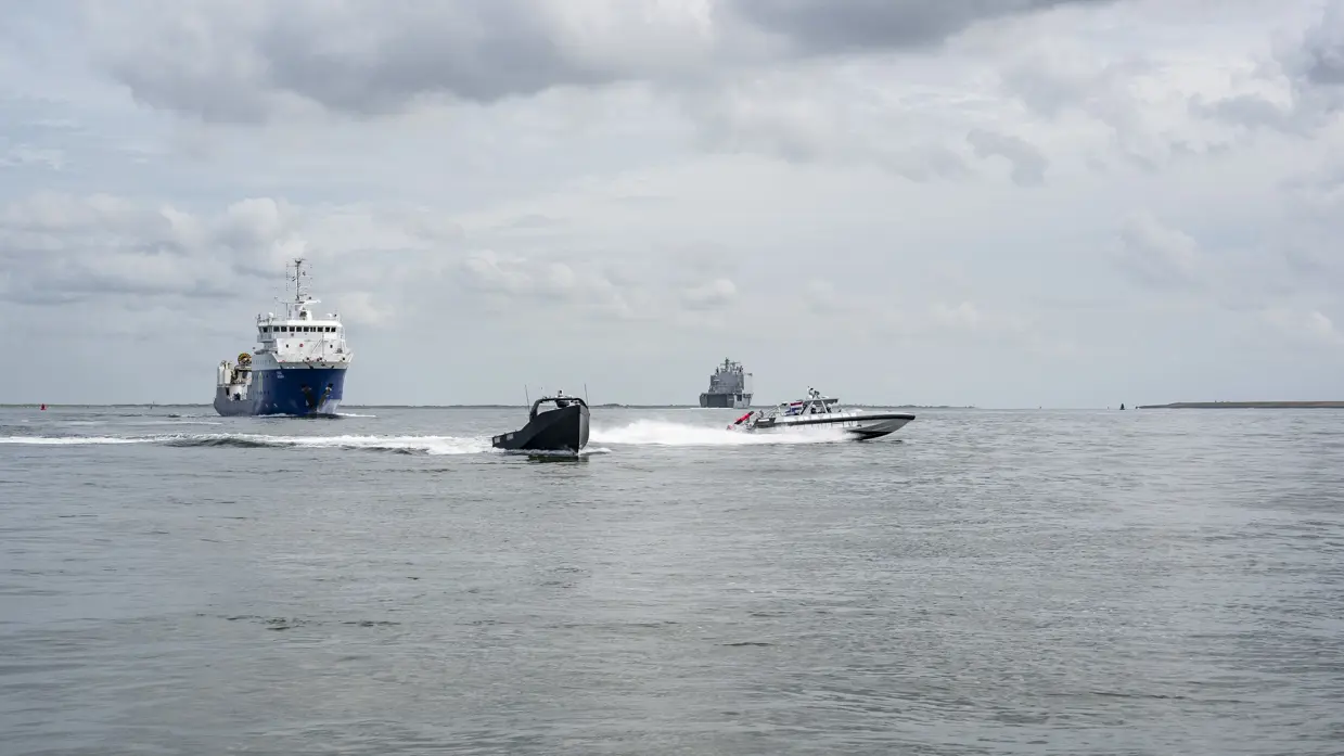 2 kleine vaartuigen en 2 grote schepen varen in formatie.