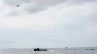een drone vliegt boven kleine onbemande boot