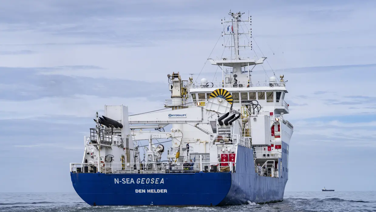 Achterkant van groot schip dat op zee vaart.