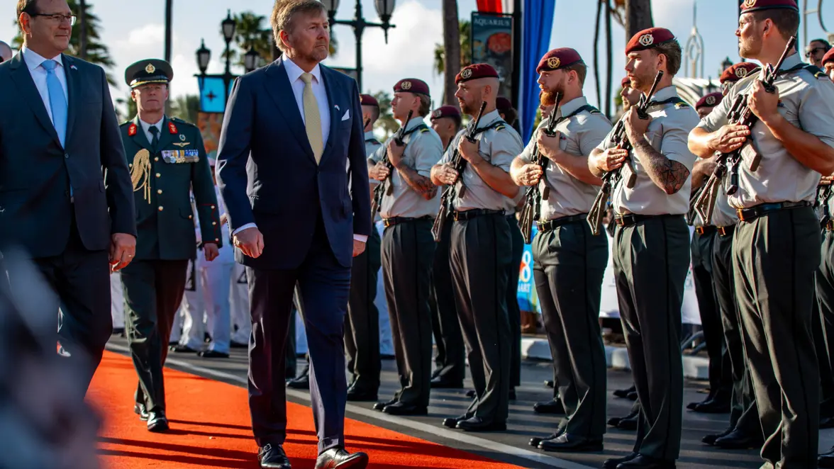 De koning loopt langs opgestelde militairen