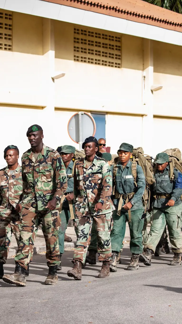 Curaçaose militairen marcheren achter elkaar aan.