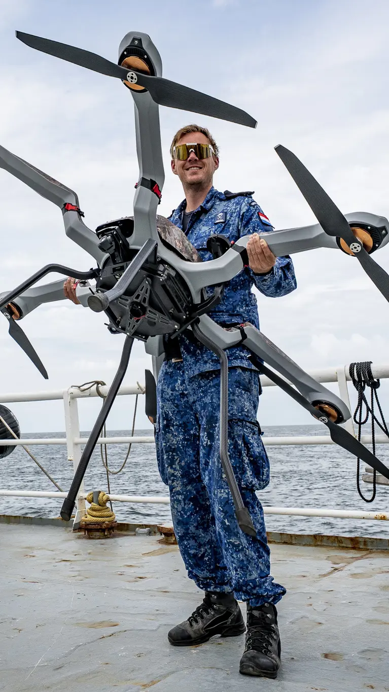 Man met drone op het dek van een schip