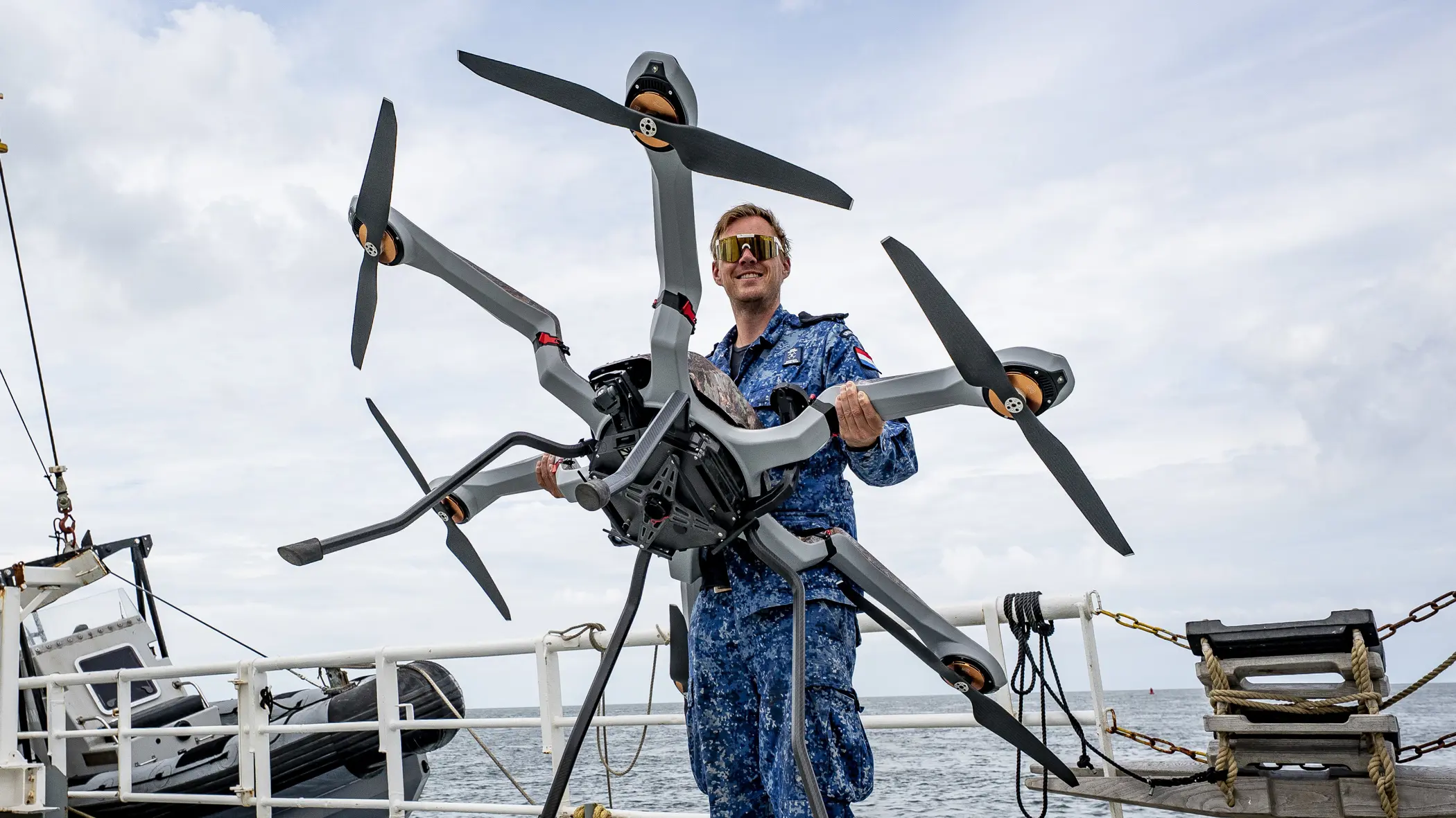 Man met drone op het dek van een schip
