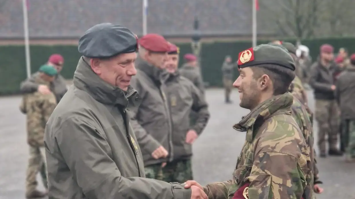 Twee militairen schudden elkaar de hand. 