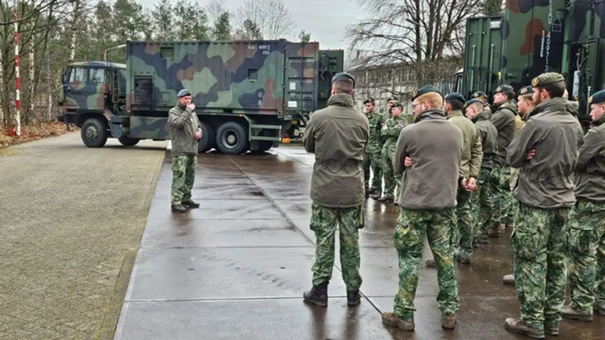 Militairen staan in een groep en praten met elkaar.