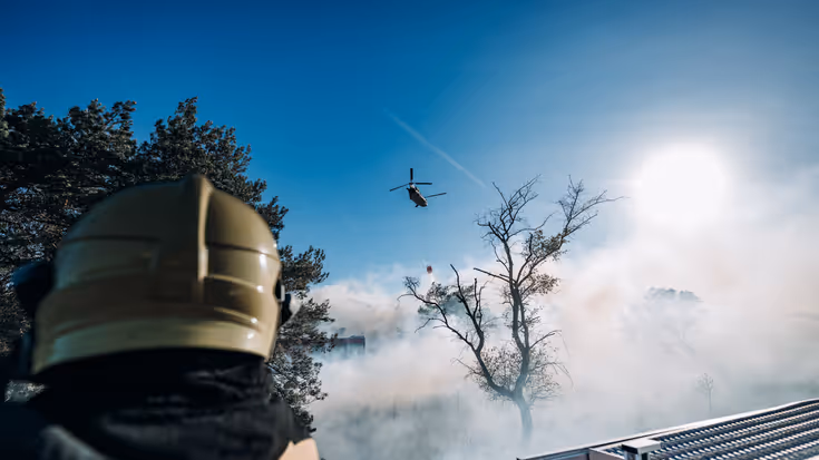 Blushelikopter boven de brand.