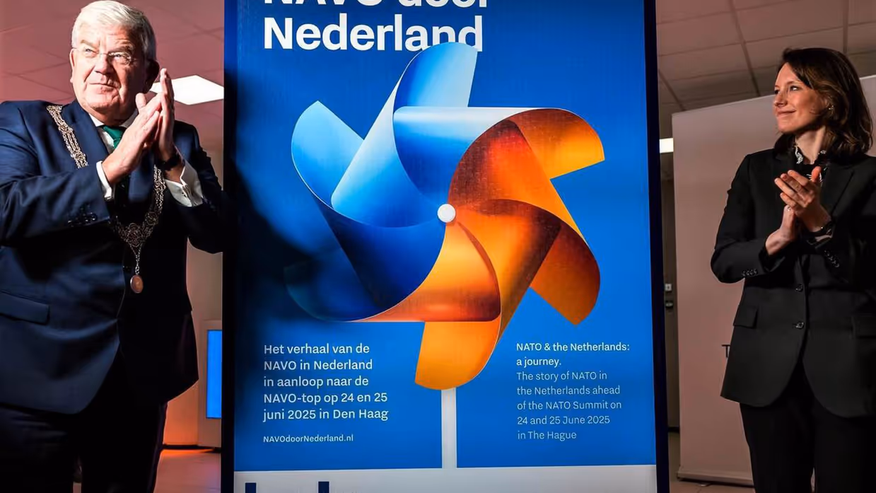 Burgemeester Jan van Zanen van Den Haag (links) en directeur van de Atlantische Commissie Anna van Zoest (rechts) staan voor een banner van de NAVO-tour door Nederland.