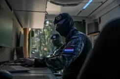 Onherkenbare militair zit achter een computer.