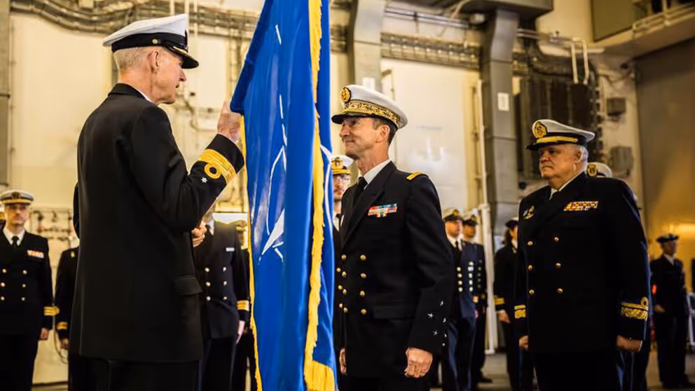 Warnaar op de rug gezien geeft een vlag aan Rear Admiral Joaquin Excagedo.
