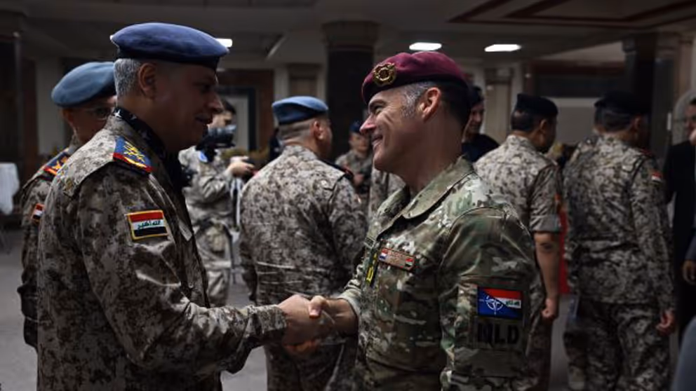 2 militairen schudden de hand.