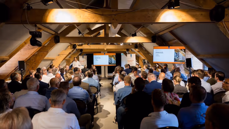 Een informatiebijeenkomst in Kasteel Woerden voor de diensten wegtransport en overslag met achterhoofden van de deelnemers en luitenant-generaal Jan Willem Maas op het podium.