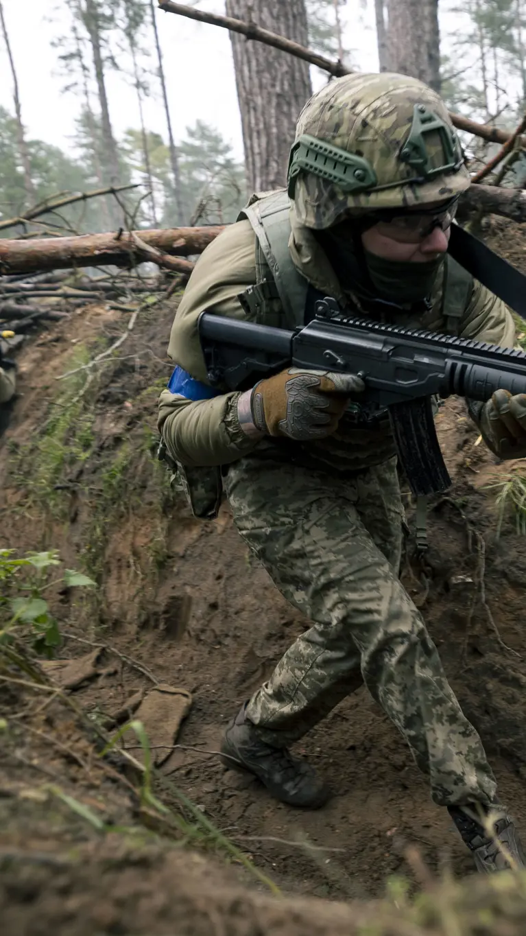 Een militair loopt door een loopgraaf.